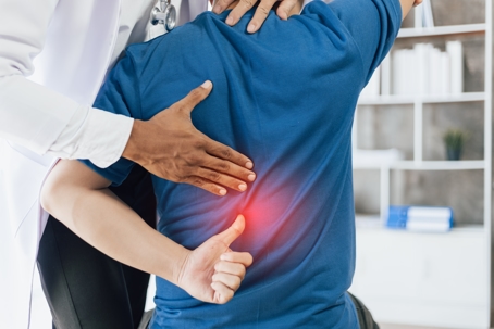 person with lower back pain at the doctors