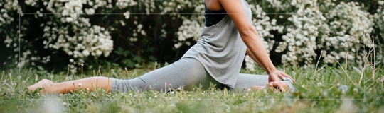 young woman with curly hair doing yoga outside in the spring