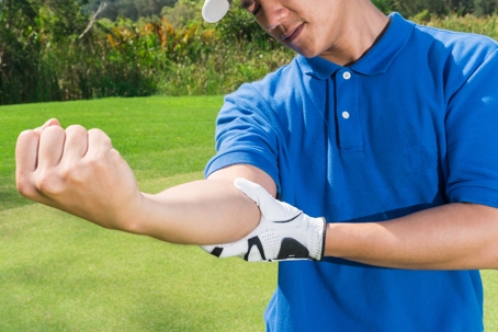 golfer out on green stretching arm