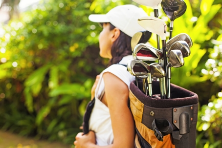 woman carrying golf clubs